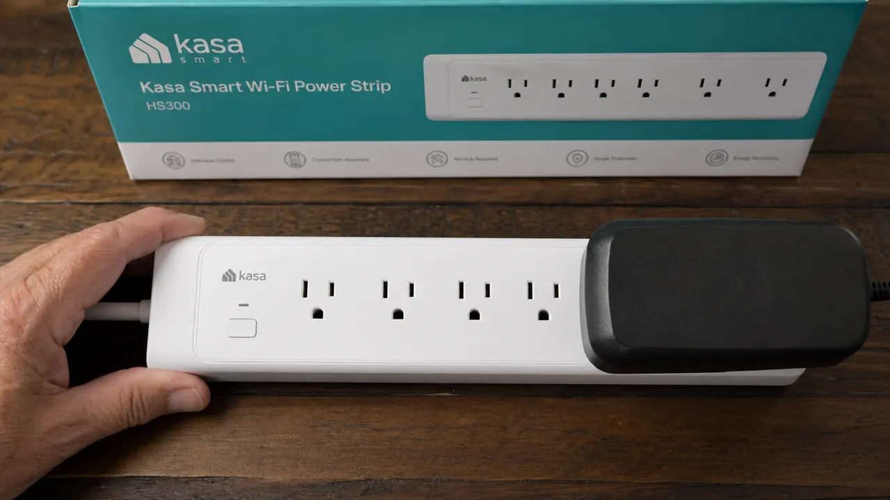 Large wall-wart power adapter plugged into the end outlet of a Kasa HS300, blocking the adjacent outlet slot